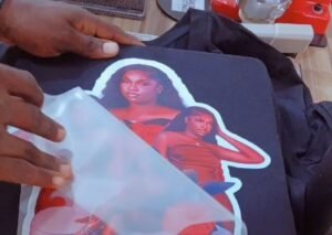 DTF transfer film being peeled from custom t-shirt